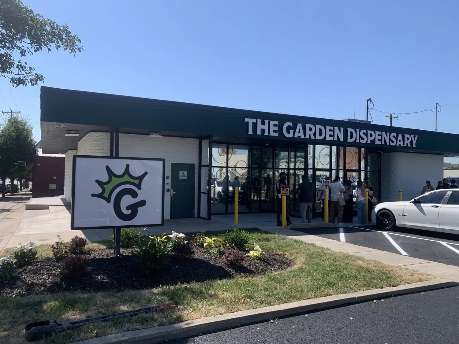 The Garden Dispensary storefront in Camp Washington on a sunny day, the crowned G sign on the lawn