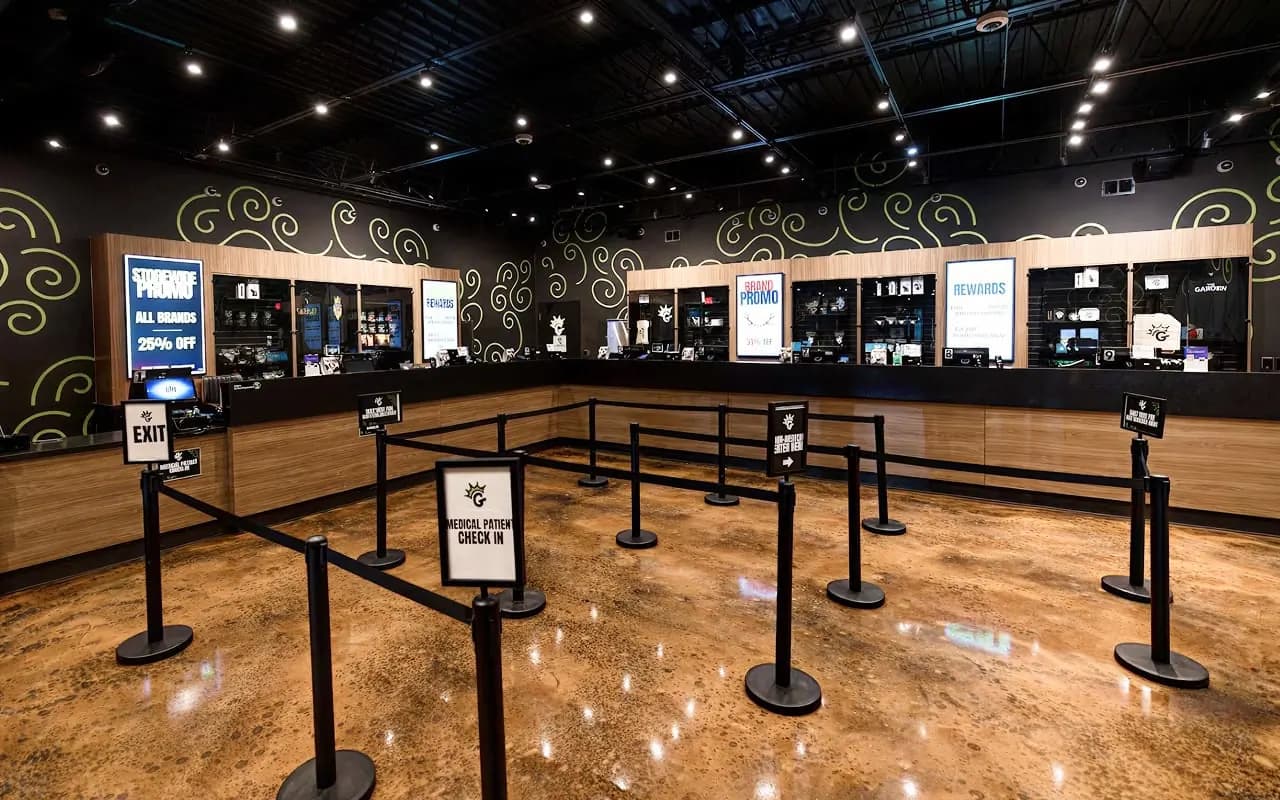 The Camp Washington sales floor: counters along black walls painted with the lime vine mural, and the pickup queue